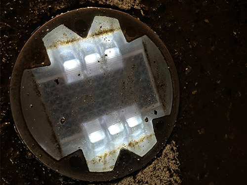 Solar road stud lights on the road after rain